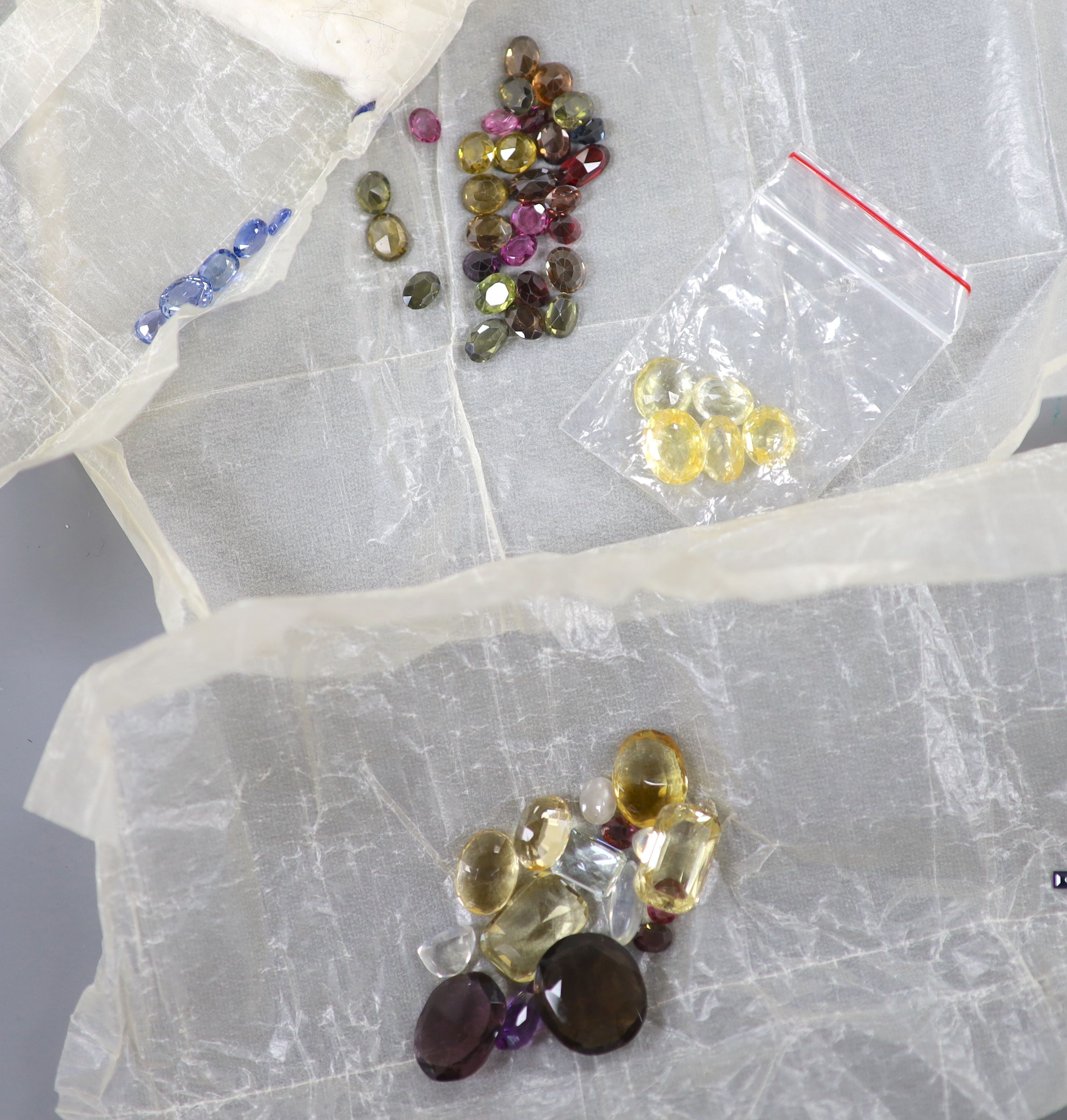 A quantity of assorted loose cut gemstones including sapphires, aquamarine, citrine and tourmalines.